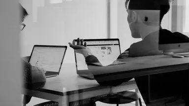 man and woman looking at computer