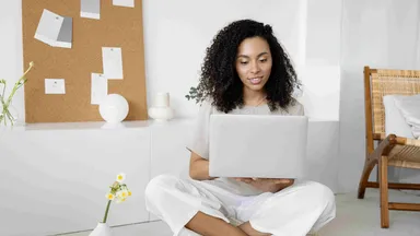 Gym owner in white pants looking at laptop